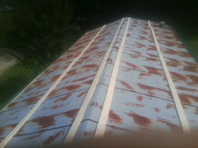 Rusted metal roof panels with new wood purlins before replacement — Storm Damage Roof Repair in Sergeant Bluff by Roofing Brothers