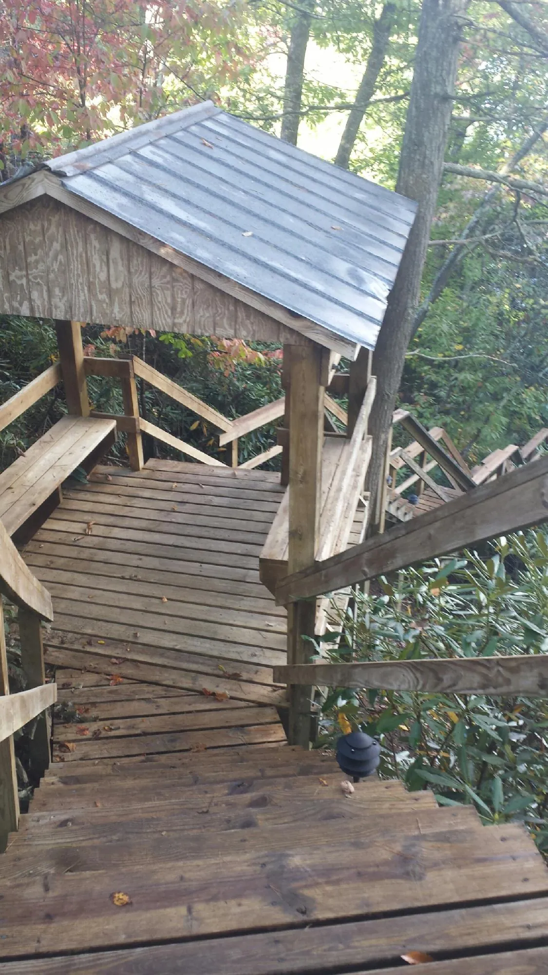 Metal roofed shelter over wooden steps on a wooded walkway — Skylight Repair & Installation work by our crew in Sergeant Bluff