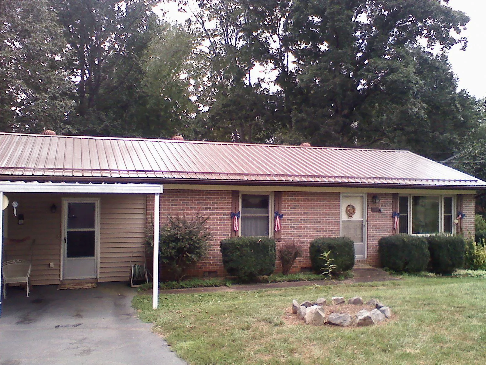 Bronze metal roof and carport on a brick ranch home — Roof Repair work by our crew in Sergeant Bluff